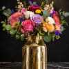 Bright, reflective gold accents meet a cheerful bouquet in this mixed-color flower