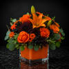 Orange roses and lilies in a square glass vase