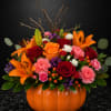 Orange lilies and red roses arranged in a pumpkin-shaped vase