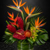 Tropical arrangement with bird of paradise, anthurium, and orchids in a glass vase