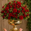Red roses and carnations in a gold pedestal vase