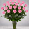 Tall bouquet of pink roses in a clear glass vase