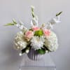 White and pink floral arrangement in a ribbed vase