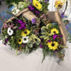 A rustic wooden frame overflowing with bright yellow daisy-like blooms and crisp