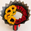 Bouquet of red roses and yellow sunflowers in black wrap with a red ribbon