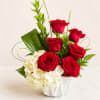 Red roses and white hydrangeas in a white vase