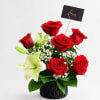 Red roses and white lilies arranged in a black vase