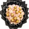 Bouquet of pale pink roses with gold-wrapped chocolates in black paper