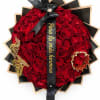 Heart-shaped bouquet of red roses with a black ribbon and gold accents