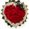 Heart-shaped bouquet of red roses with white baby's breath and a black ribbon