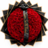 Heart-shaped bouquet of red roses wrapped in black paper with a ribbon