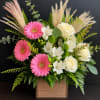 Pink gerberas and white roses in a wooden box with greenery.