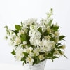 White flowers arranged in a woven basket with green leaves