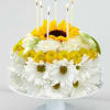 Sunflower and white daisy arrangement with lit taper candles on a pedestal stand