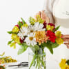 Mixed bouquet of daisies, chrysanthemums, and alstroemeria in a glass vase