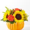 Sunflowers and orange roses arranged in a pumpkin-shaped container