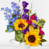 Colorful floral arrangement with sunflowers, roses, and tall candles