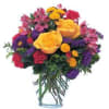 Mixed bouquet of yellow roses, purple and pink flowers in a clear glass vase