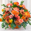 Halloween bouquet with a skeleton, spiders, and orange flowers in a pumpkin container