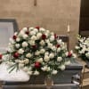 A beautiful casket spray with carnations and roses accompanied by greenery. 

If
