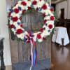 Wreath made of roses, delphiniums, chrysanthemum, carnations, and greenery. 

Perfect arrangement for