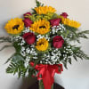 Sunflowers and red roses in a glass vase with a red ribbon