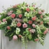 Large horizontal spray of pink roses and carnations with white lilies and other white flowers