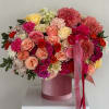Large pink and peach flower arrangement in a velvet hatbox with ribbon
