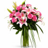 Pink roses and white lilies arranged in a clear glass vase