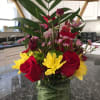 Red roses and yellow daisies with pink accents and greenery in a