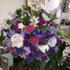 Large bouquet of purple, pink, white, and blue flowers in a glass vase