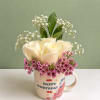 A simple birthday arrangement of creamy white roses with soft pink filler