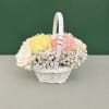White wicker basket with pastel roses, carnations, and small white filler flowers