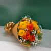 Bouquet of orange roses and yellow chrysanthemums wrapped in gold paper