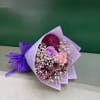 Bouquet of purple, pink, and white flowers wrapped in lavender paper