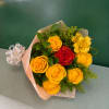 Bouquet of yellow and red roses with yellow alstroemeria in pink wrap