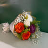 Bouquet of orange roses, white blooms, and purple flowers wrapped in paper