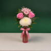 Pink roses and white chrysanthemum in a pink vase with a ribbon