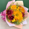 Bouquet of yellow and burgundy flowers wrapped in pink paper with a ribbon