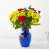 Yellow daisies and red carnations in a blue glass vase