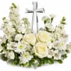 White floral arrangement with roses and a silver cross centerpiece