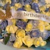 Bouquet of pale yellow and blue roses with a birthday ribbon