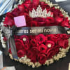 Red rose bouquet with baby's breath, black wrap, and a decorative crown