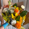 Mixed bouquet of roses, chrysanthemums, and carnations wrapped in brown paper