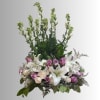 Tall floral arrangement with white lilies and pink roses in a low base