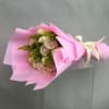 Pink and cream rose bouquet wrapped in pink paper with a ribbon