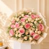 Bouquet of pink and cream roses wrapped in beige paper