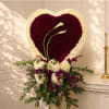 Heart-shaped floral arrangement with two white calla lilies and purple and white flowers