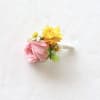 Pink and yellow floral boutonniere with a wrapped stem