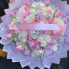 Pink and white rose bouquet wrapped in lavender paper with a ribbon
